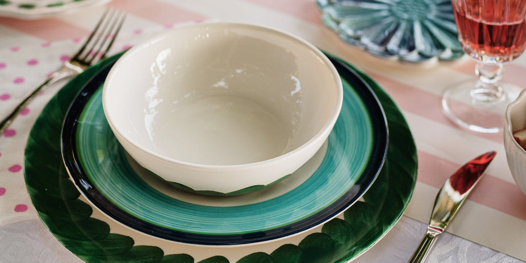 Viva Lisbon Italian dinnerware place setting with green and turquoise plates and a white bowl on a colorful table.