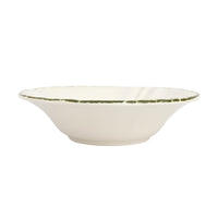 White ceramic serving bowl with a green rim on a white background