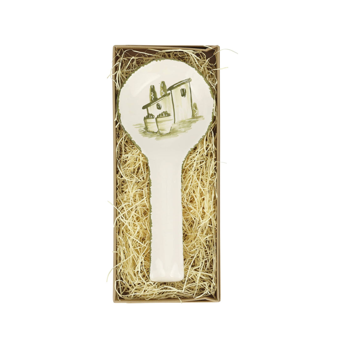 Decorative rest spoon with a house design in a box filled with straw