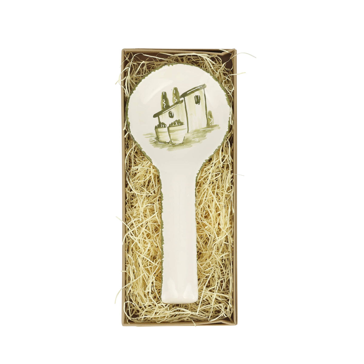 Decorative rest spoon with a house design in a box filled with straw