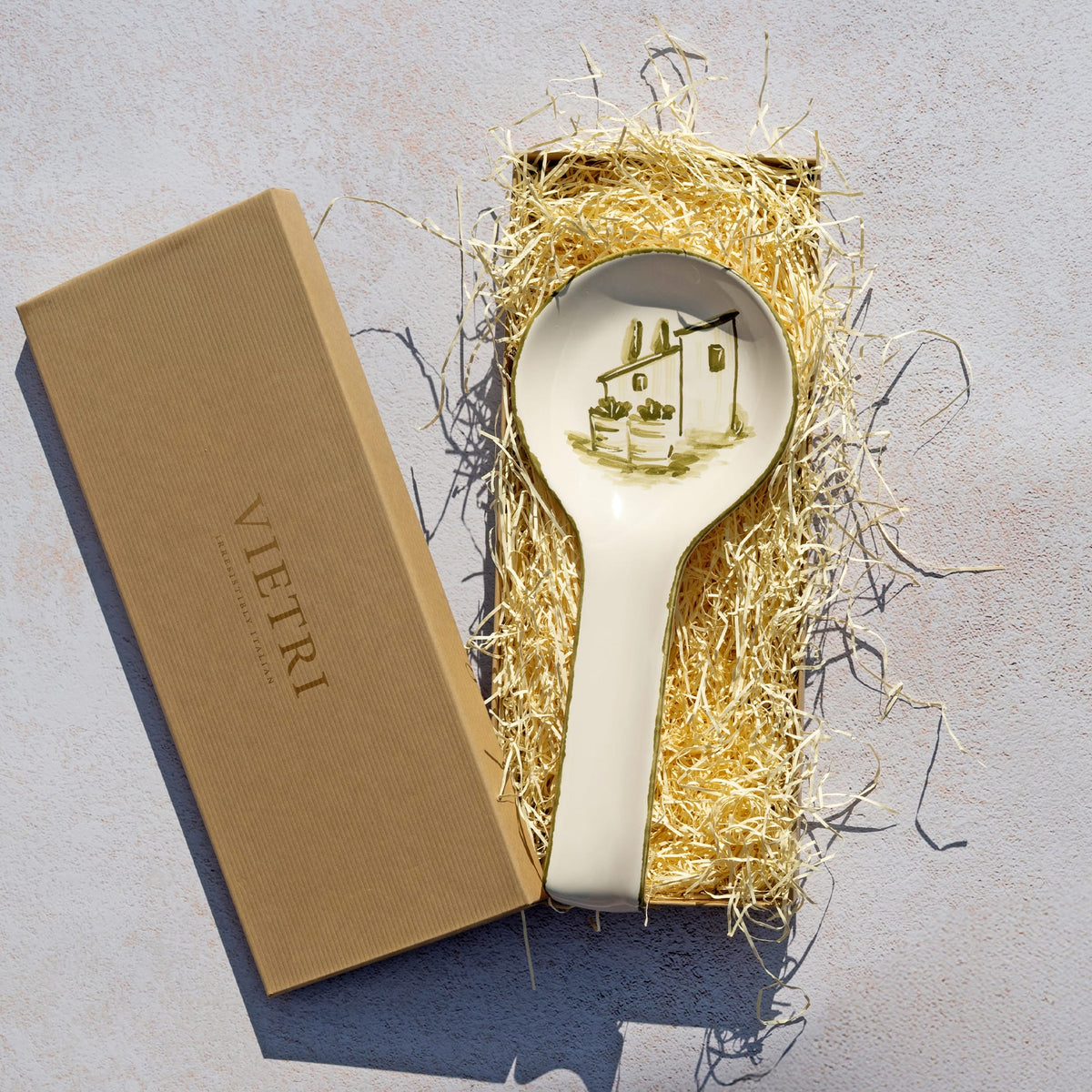 Decorative spoon rest with design in a box on a textured surface